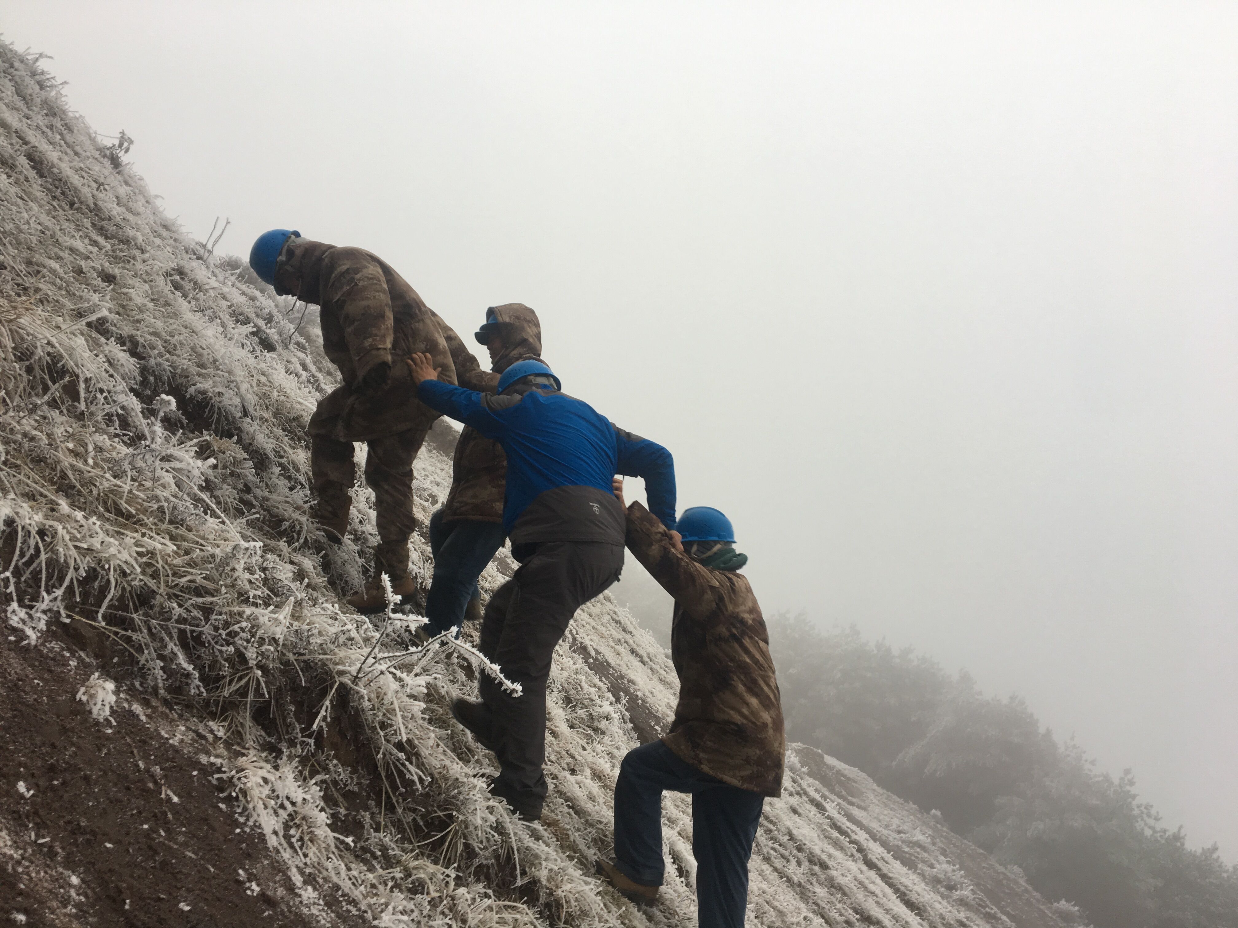 互相攙扶，勇登高峰。（李健攝）