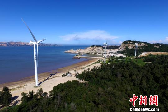 沿海灘而建的風(fēng)力發(fā)電機(jī)。　王東明 攝