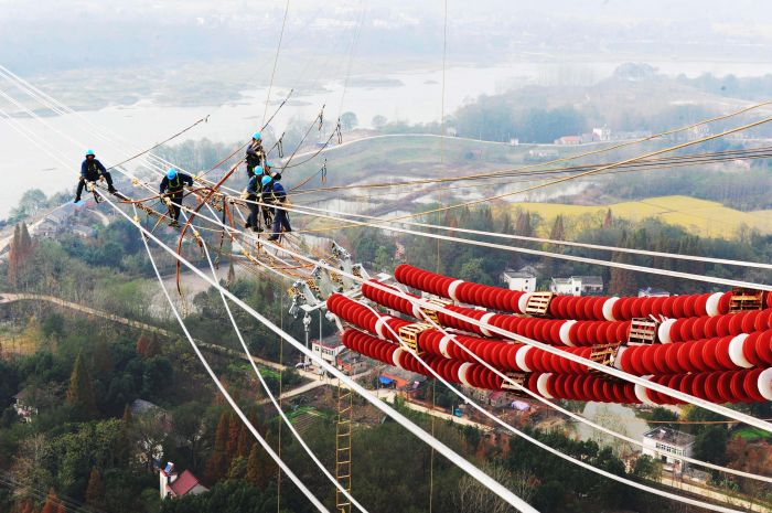 國(guó)網(wǎng)安徽電力施工人員在安徽蕪湖市南陵縣的80多米高空進(jìn)行導(dǎo)線附件安裝施工。（鄭賢列攝）